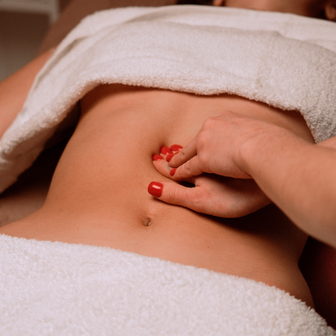 Woman receiving upper abdominal massage to support solar plexus chakra healing