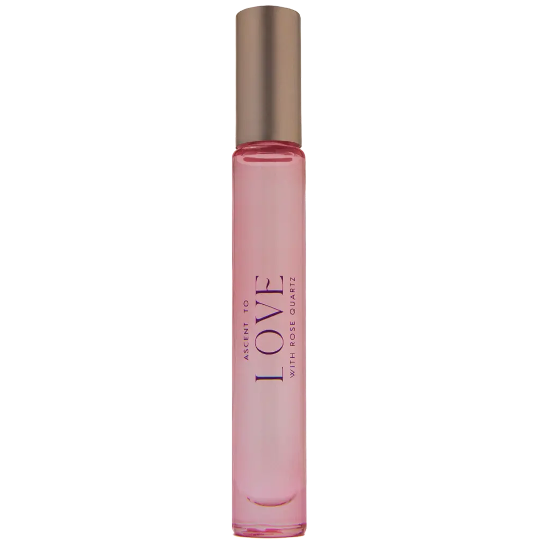 A perfume bottle labeled Ascent to Love with a rose quartz applicator, suggesting a luxurious and spiritual product.