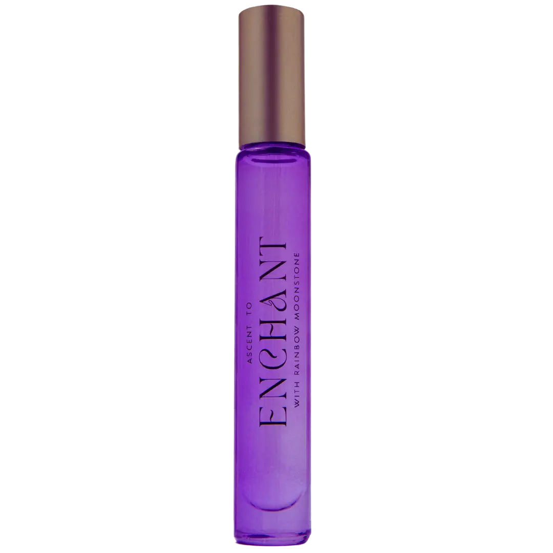 The perfume, featuring a mystical allure, comes in a purple bottle with a brown cap and is labeled as *NEW* Ascent to Enchant With Rainbow Moonstone Perfume by ASCENTION BEAUTY CO.